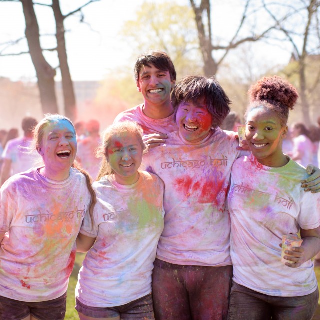A group of students post outside covered in colorful powder during Holi, a Hindu spring festival.