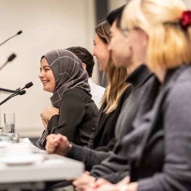 A panel of students grin and lean forward into microphones.