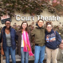 A group of four students post in front of an ivy-covered wall in front of the Court Theatre.