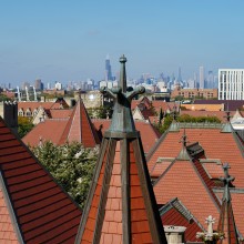 The city of Chicago is seen behind the red rooftops of UChicago's gothic buildings.