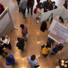 An aerial shot of a group of students presenting posters at an undergraduate research symposium.