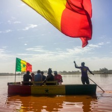 A group of students and a guide ride on a boat at the Pink Lake.