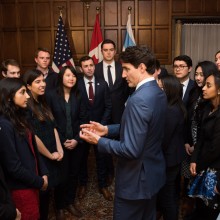 A group of students speak with Prime Minister Justin Trudeau as part of an event hosted by the Institute of Politics