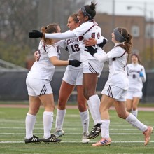 Members of UChicago's women's soccer team celebrate during a game.