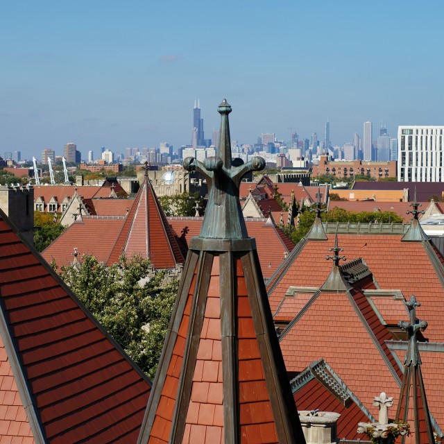 The city of Chicago is seen behind the red rooftops of UChicago's gothic buildings.