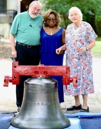 Christian Haller (left) and Helen Haller (right), who donated the money for the new bells, stand with Zenobia Johnson-Black, the widow of Timuel Black, by the bell dedicated to him.