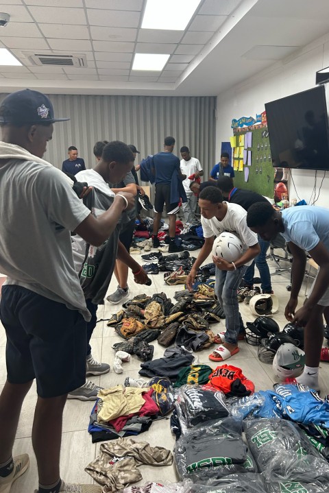 Young baseball players from the D.R. pick up donated gear and equipment.