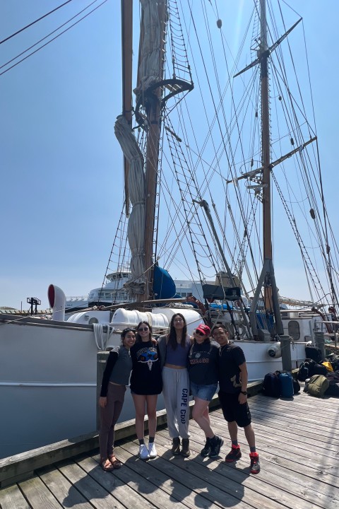 UChicago students stand next to the boat they lived on for eight days during the “Biological Oceanography” excursion.