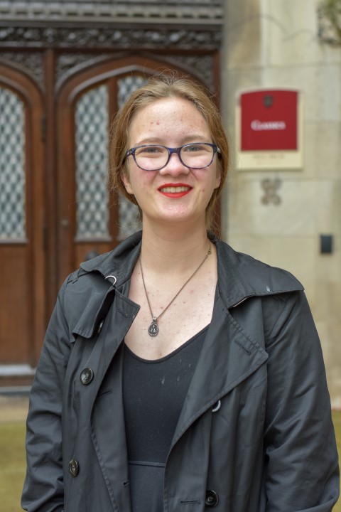 Hannah Trower poses in a black coat outside of Classics Hall.