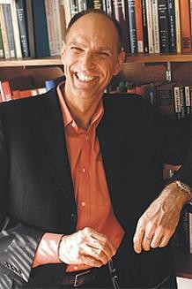 Portrait of Andreas Glaeser in front of shelves of books.