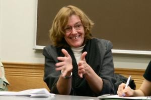 Candace Vogler spreads her hands sitting at a table in a classroom.