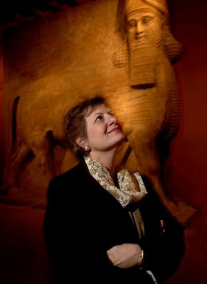 Martha Roth stands near sculptures in the Oriental Institute.