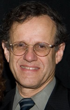 A close-up headshot of a male-presenting person.