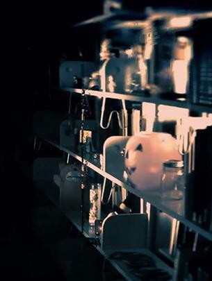 A blurry, mysterious image of a bookshelf with a jack-o-lantern on it.