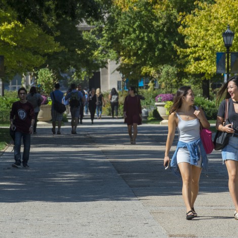Summer students walk down the middle of the Quad to class