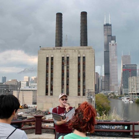 Chris Skrable speaks into a microphone on an Oct. 8 Urban Hike along the path of the Great Chicago Fire.