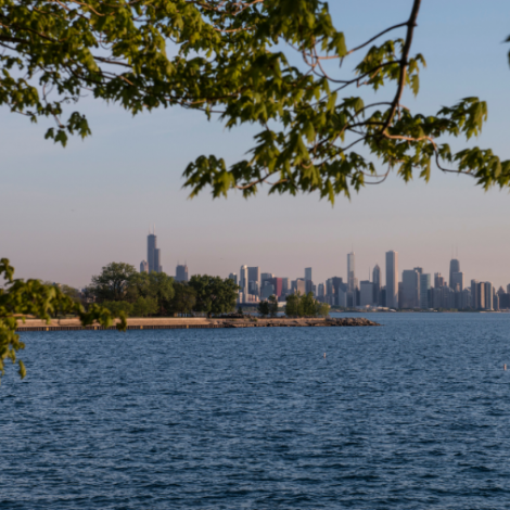 Calm, blue Lake Michigan with the Chicago city skyline in the background before sunset